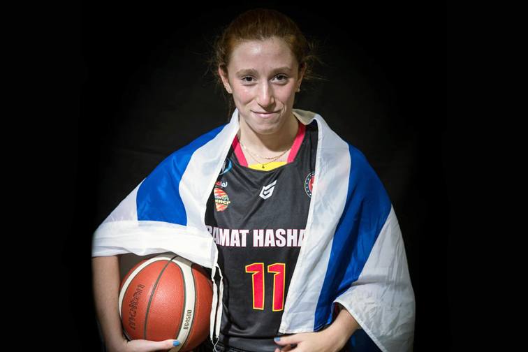 Leila, wearing her basketball jersey with an Israeli flag draped over her shoulders