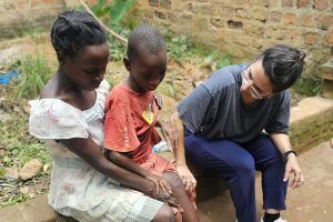 Avivit doing physical therapy with a child in Uganda